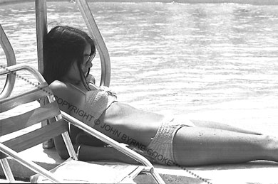 Mimi Fariña reclining by the pool
